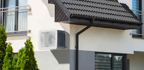 Le cache climatisation OUTSTEEL, modèle Bubbles bicolore, installé directement sur le mur de la maison